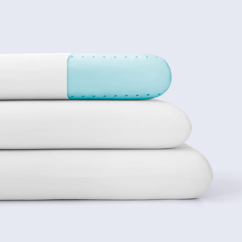 Stack of white cooling pillows against a white background