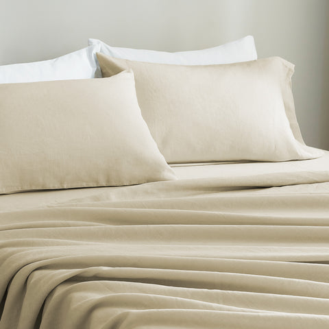 Beige European linen bedding set with pillows on a neutral background