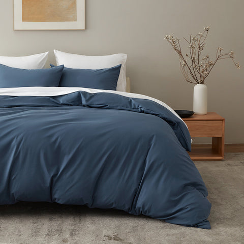 Bed with midnight blue bedding in a bright bedroom featuring cottonnest collection