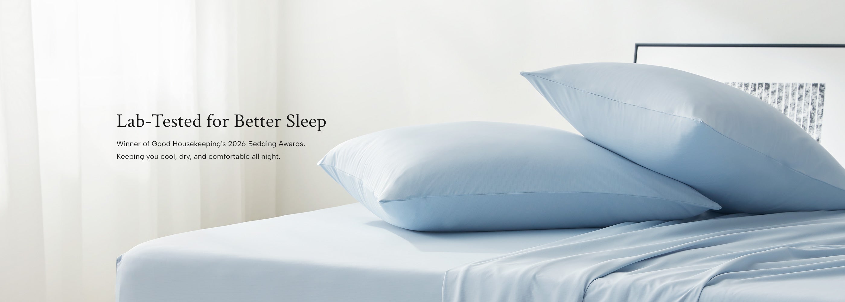 Light blue cooling sheet bedding set with pillows on a bed in a bedroom setting.