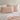 a close-up view of blush cotton jersey pillowcase set on a blush bed against a neutral wall.
