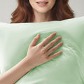Person holding a cooling green pillow with a soft texture
