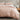 blush cotton duvet cover set on a bed with a wooden nightstand and decorative items.
