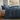 long side view of midnight cotton duvet cover set on a bed in a room with a window showing a garden view
