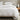 White cotton duvet cover set on a bed with a wooden nightstand and decorative items.