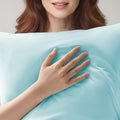 Woman holding a light blue pillow with a soft texture